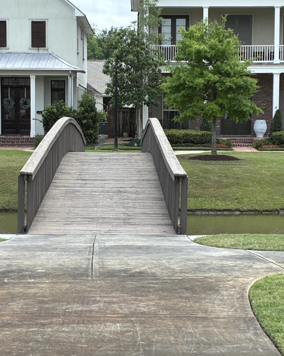 Arched wooden footbridge over the canal at The Preserve at Harveston