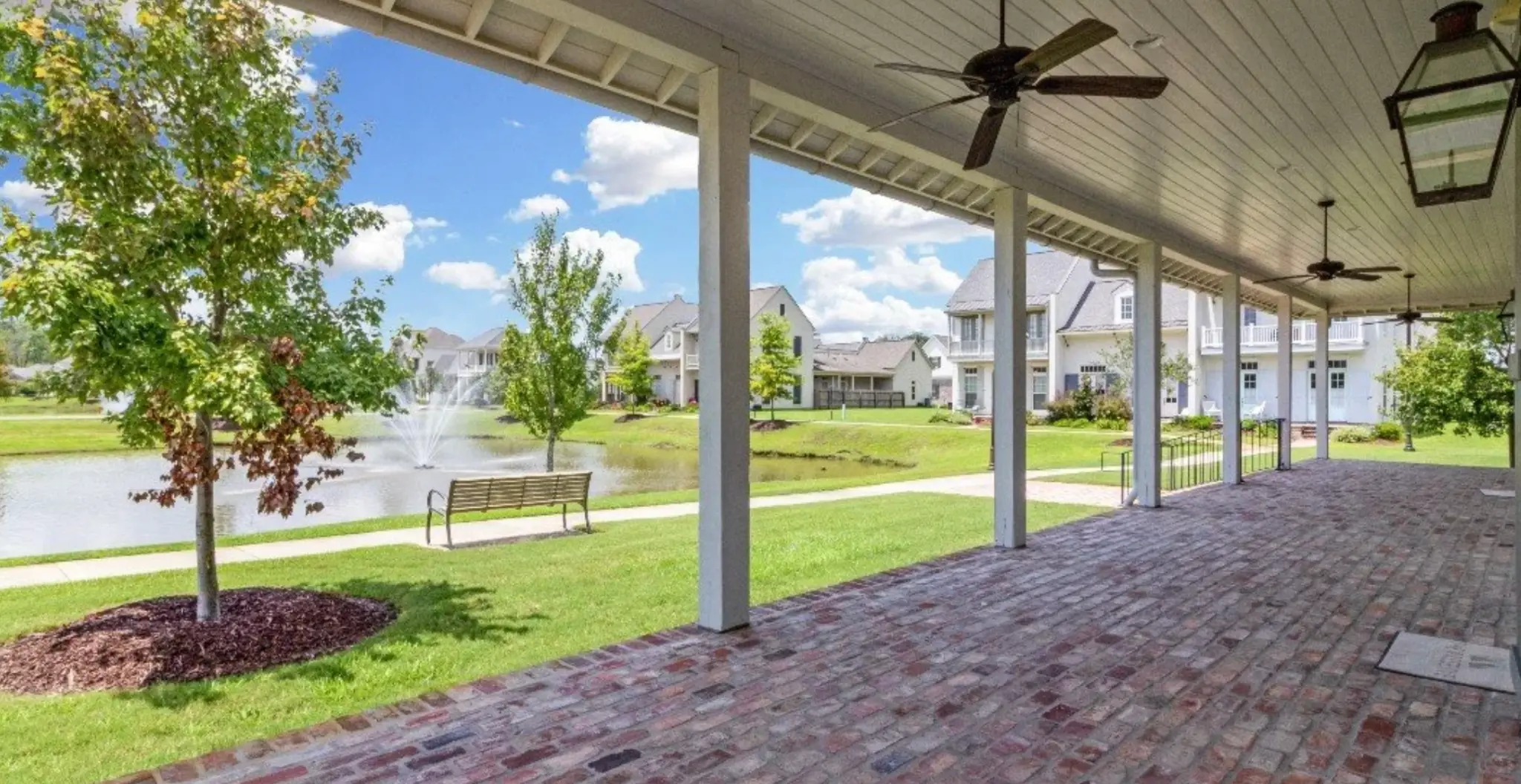 Covered back porch with ceiling fans and gas lanterns overlooking the lake and fountain